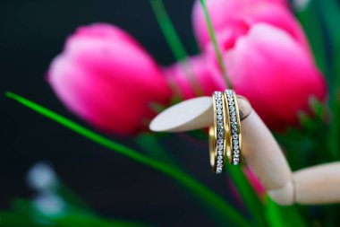 Sahte pembe bir lalenin içinde duran elmas alyans. Yaklaş.