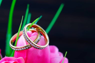 Sahte pembe bir lalenin içinde duran elmas alyans. Yaklaş.