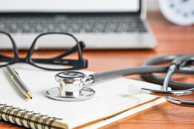 Doktor kontrolleri için tıbbi steteskop. Doktor not defterindeki dizüstü bilgisayardan tıbbi konsept olarak.