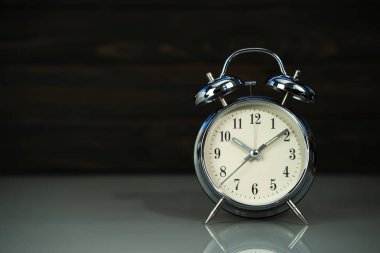 Ahşap arkaplan yakınındaki masada geri alarm saati