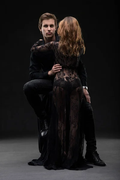 Sexy jeune couple tourné embrassant dans le noir — Photo