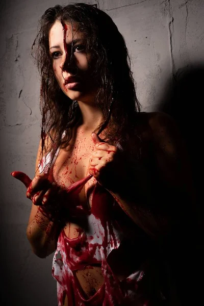 Sexy girl splashed with blood against gray wall — Stock Photo, Image