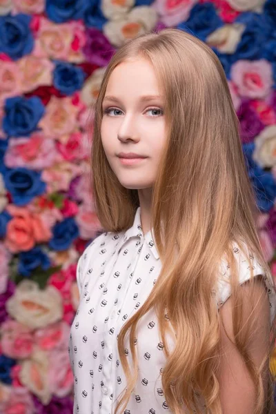 Mooie tiener blonde portret op de muur van de bloem — Stockfoto