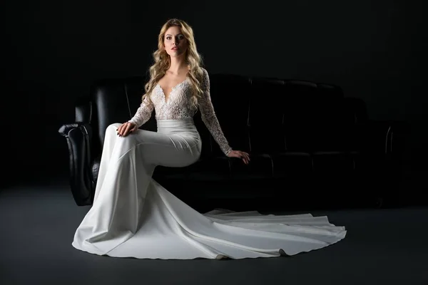 Kobieta w sukni koronki luksusowe siedzi na kanapie — Zdjęcie stockowe