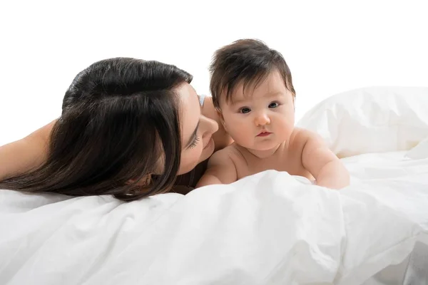 Ung mamma ligger i sängen med sin lilla baby pojke — Stockfoto