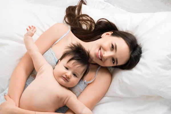 Mãe feliz na cama com bebê menino tiro de ângulo alto — Fotografia de Stock