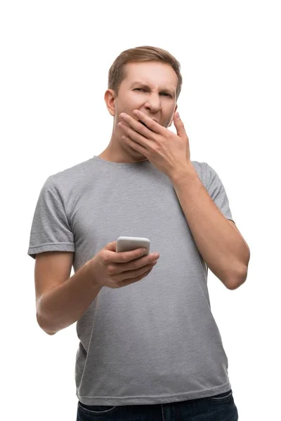 Sleepy gapende man met een geïsoleerde portret van telefoon — Stockfoto