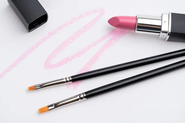 Maquillaje pinceles y lápiz labial rosa vista aislada — Foto de Stock