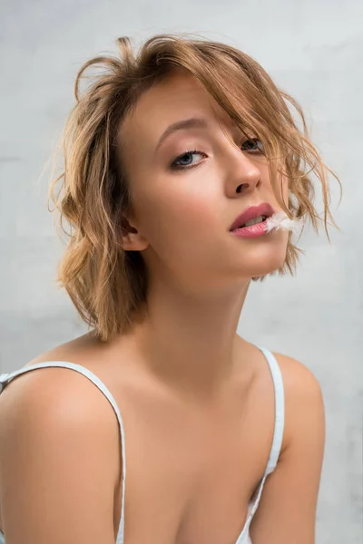 Blonde with haircut and feather in her mouth shot — Stock Photo, Image