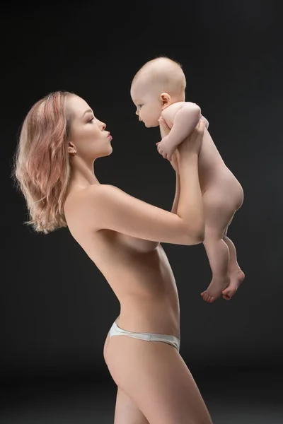 Pretty mother topless holding her baby profile shot — Stock Photo, Image