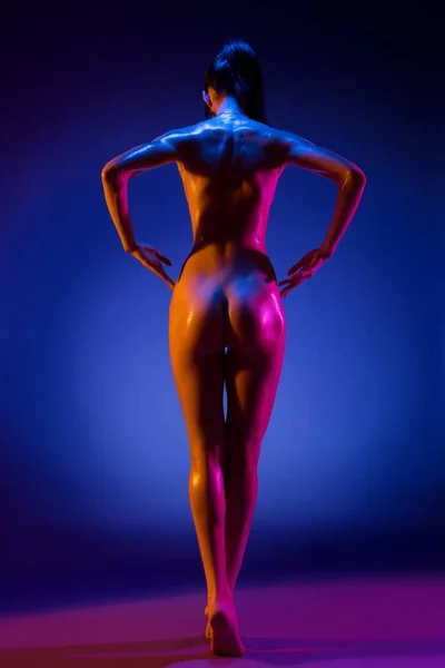 Mulher magra nua em luz violeta retrovisor — Fotografia de Stock