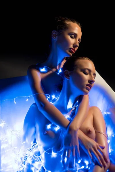 Nude women in bath in garland lights in the dark — Stock Photo, Image