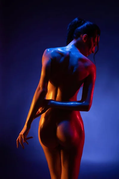 Nude girl in blue and pink light rearview — Stock Photo, Image