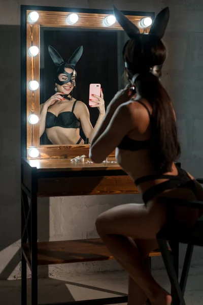 Mulher em lingerie e orelhas de coelho fazendo selfie — Fotografia de Stock