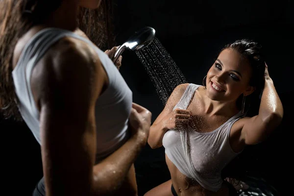 Brunettes in sexy natte toppen in de douche in het donker — Stockfoto