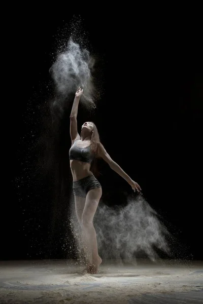 Meisje in lingerie dansen in het stof in het donker — Stockfoto