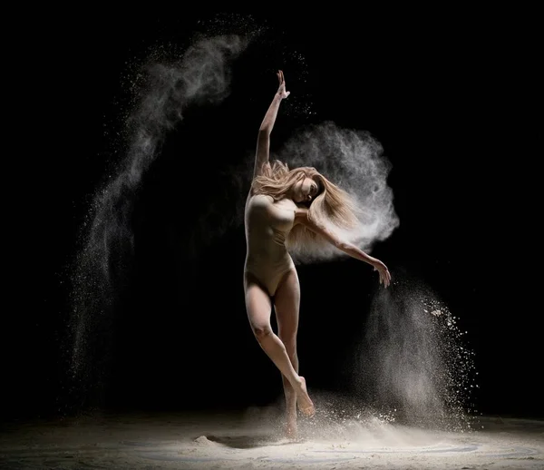 Hermosa chica bailando en el polvo en la oscuridad — Foto de Stock