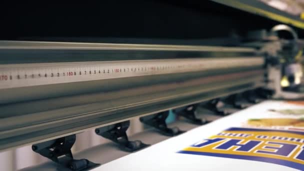 Κεφαλή εκτύπωσης των βιομηχανικών εκτυπωτών κάνοντας πολύχρωμο πανό με επιγραφές — Αρχείο Βίντεο