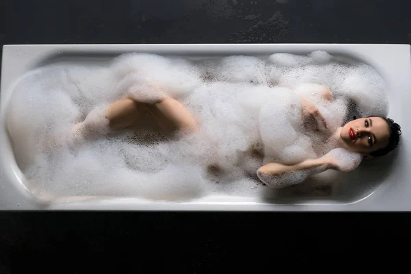 躺在浴缸泡沫中的感性女士 — 图库照片