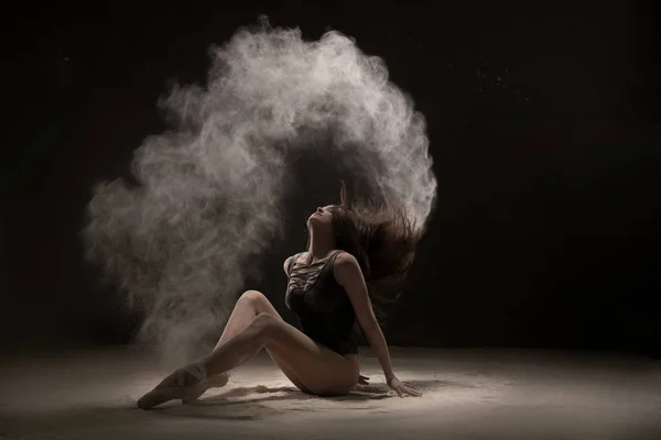 Brunette au sol dans un nuage de poussière blanche — Photo