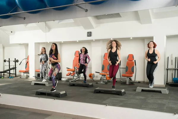 Junge Frauen beim Training auf Trittbrettern in einem Fitnessstudio — Stockfoto