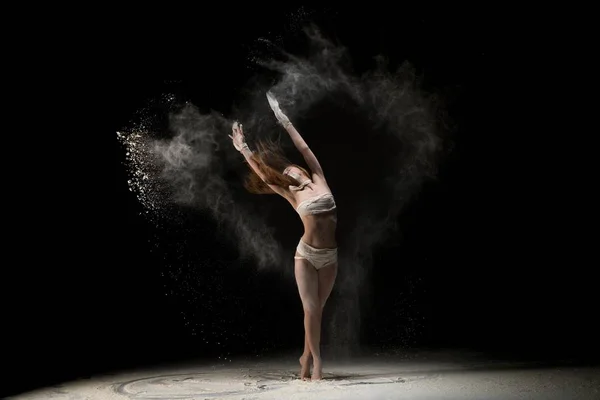Schlanke Frau tanzt mit Sand — Stockfoto