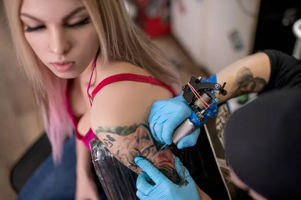 Crop master tattooing arm of sensual blond — Stock Photo, Image