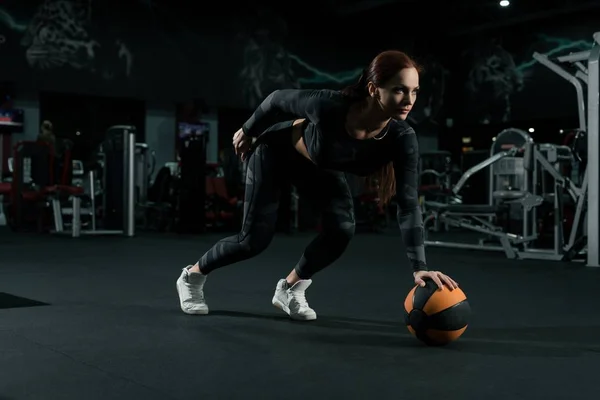 Slim woman in sportswear training with a ball — Stock Photo, Image