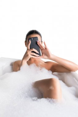 Telefon ile köpük banyoda güzel esmer