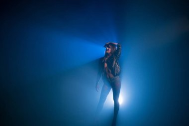 Esmer siyah ceket ve kot şort giyiyor