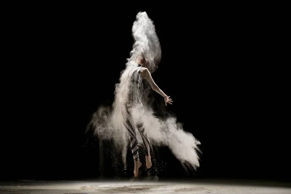 Mujer elegante bailando en la nube de polvo en la oscuridad — Foto de Stock