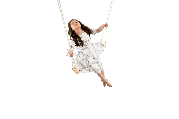 Adorable girl riding high on swings — Stock Photo, Image