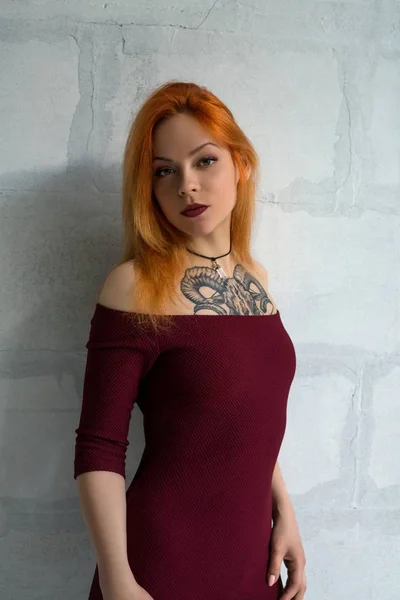 Hot red-haired girl with tattoo in burgundy dress — Stock Photo, Image