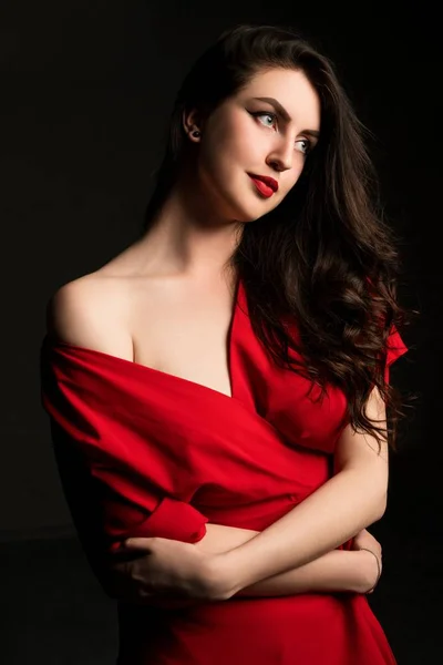 Vacker kvinna i rött på svart bakgrund — Stockfoto