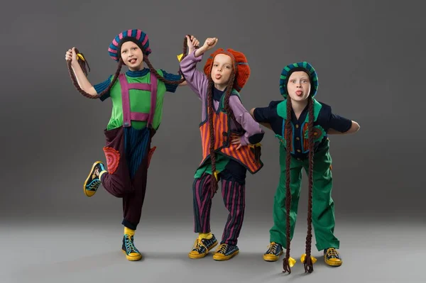 Les enfants en costumes colorés grimaçant regardant la caméra — Photo