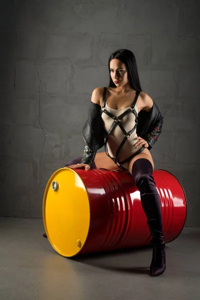 Sexig tjej i underkläder sitter på Iron Barrel shot — Stockfoto