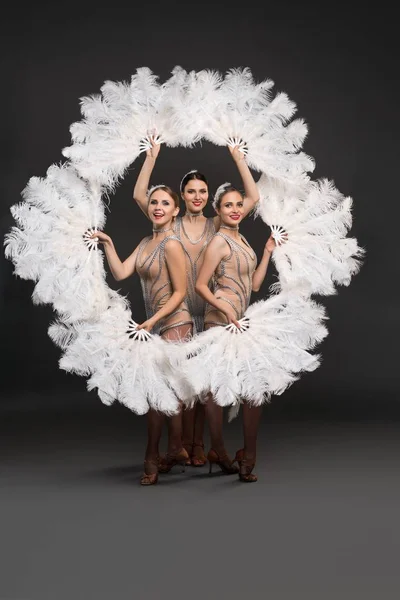 Шоу-дівчата з білими вентиляторами пір'я зняті — стокове фото