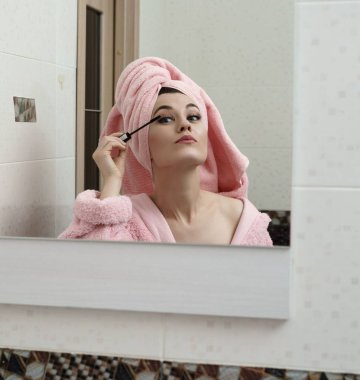 Aynaya bakarken rimel kullanan seksi kadın