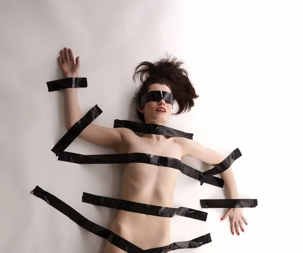 BDSM. Blindfolded nude woman tied with duct tape