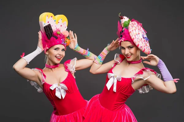 Playful women in original hats and dresses shot — Stock Photo, Image