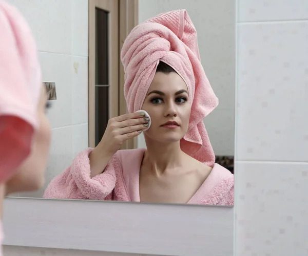 Beautiful woman cares for skin in mirror — Stock Photo, Image