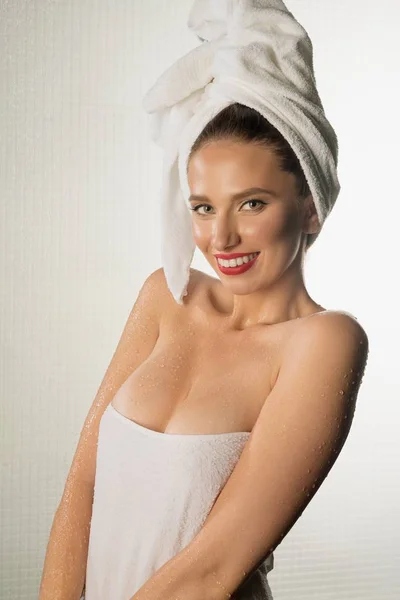 Счастливая девушка завернутая в полотенце после душа — стоковое фото