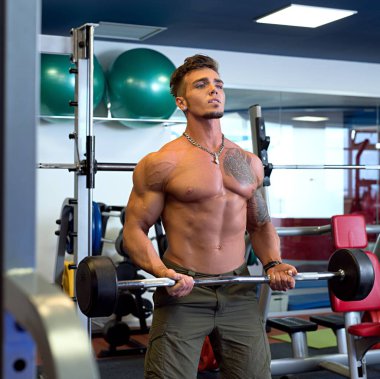 Yakışıklı dövmeli adam barbell ile eğitim