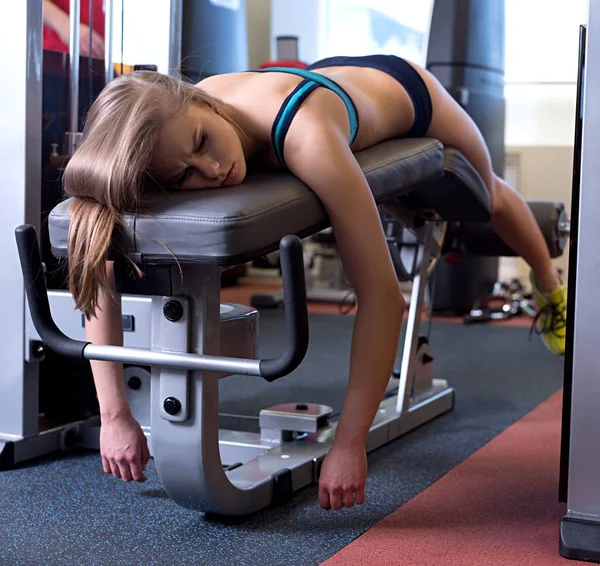 Deporte. Imagen de chica cansada tumbada en el banco del gimnasio —  Fotos de Stock