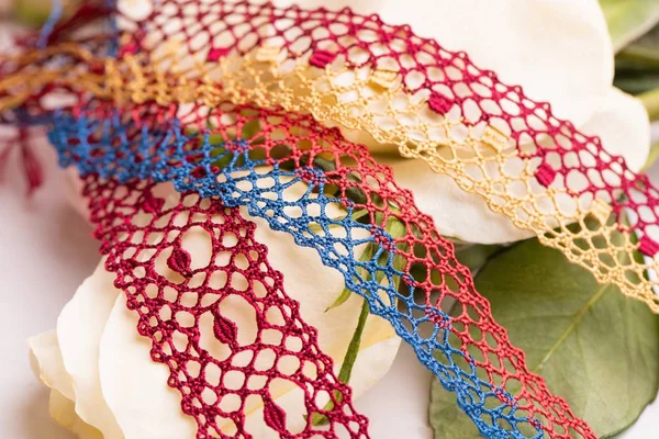 Color lace ribbons among flowers shot — Stock Photo, Image