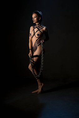 Esmer, çıplak ve karanlıkta bir çarşaf.