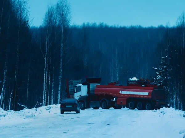 Camión de madera lleno de madera que conduce a lo largo de carretera nevada —  Fotos de Stock