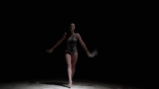 Bailarina elegante en cuerpo negro arroja polvo en la oscuridad — Vídeos de Stock