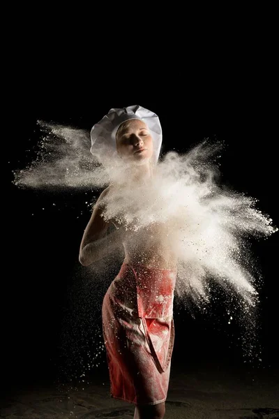 Assadeira sensual fêmea em avental vermelho com explosão de poeira — Fotografia de Stock