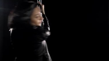 Sexy woman in black lingerie and jacket dancing near pilon
